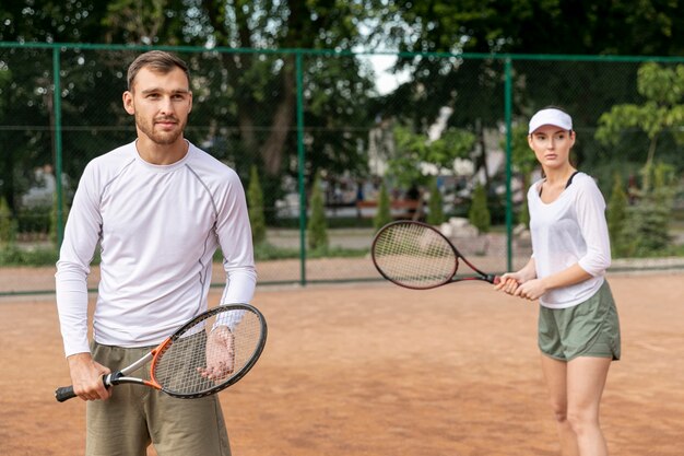 Vista frontal pareja jugando tenis