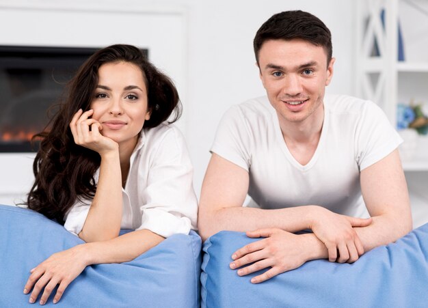 Vista frontal de la pareja posando juntos en el sofá