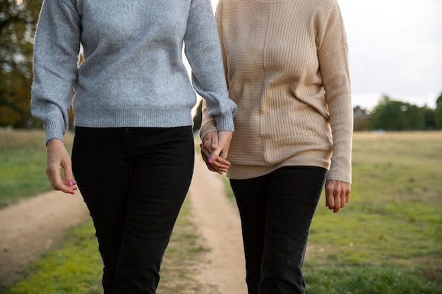 Foto gratuita vista frontal pareja queer tomados de la mano