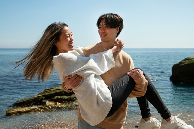 Vista frontal pareja romántica en la playa