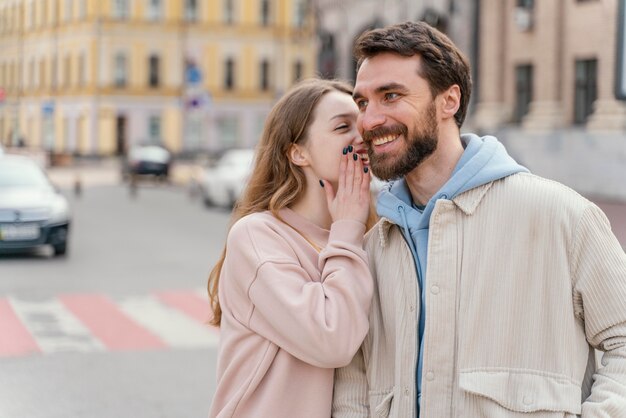 Vista frontal de la pareja sonriente al aire libre en la ciudad