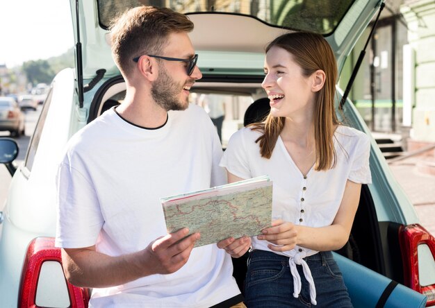 Vista frontal de la pareja sonriente con mapa