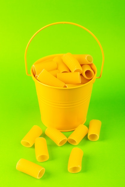 Una vista frontal de pasta dentro de la cesta formada cruda dentro de la cesta amarilla sobre el fondo verde comida comida italiana espagueti
