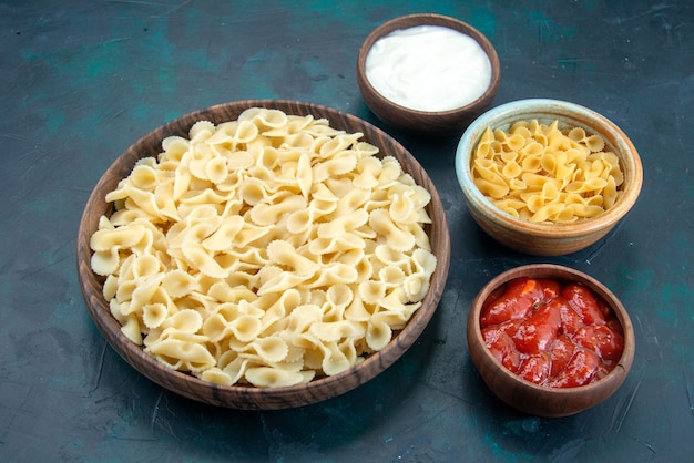 Vista frontal de pasta italiana cookied con salsa en el escritorio azul