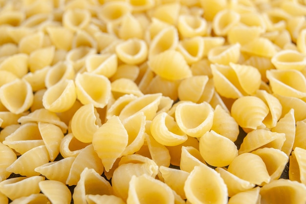 Vista frontal pasta italiana cruda sobre fondo gris color pasta italia comida foto masa muchos