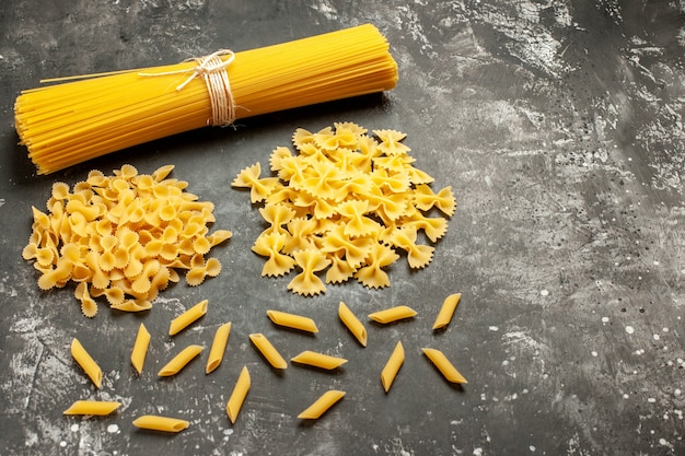 Foto gratuita vista frontal de pasta italiana larga con poca pasta cruda en comida de cocina de masa de color gris claro foto comida