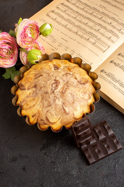 Foto gratuita una vista frontal del pastel de chocolate dentro del molde junto con barras de chocolate dulce delicioso pastel de panadería pastelería dulzura