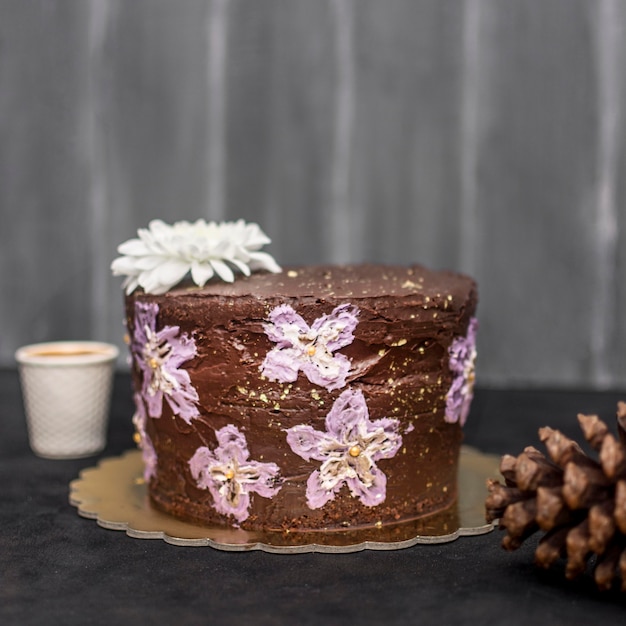 Vista frontal del pastel con piña y flores.
