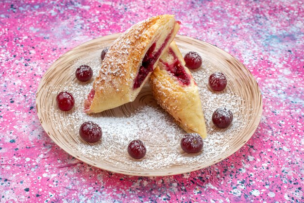 Vista frontal de pasteles de cerezas deliciosas y dulces en rodajas con cerezas agrias frescas dentro de la placa