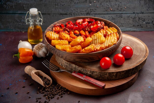 Vista frontal de patatas al horno con verduras cocidas en el espacio oscuro