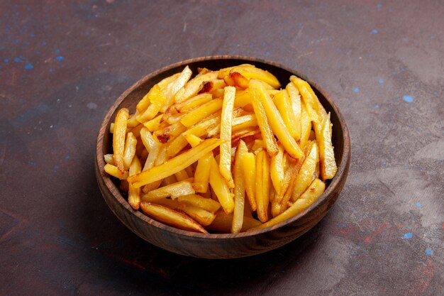 Vista frontal patatas fritas sabrosas patatas fritas dentro de la placa en la superficie oscura comida cena ingredientes del plato patata