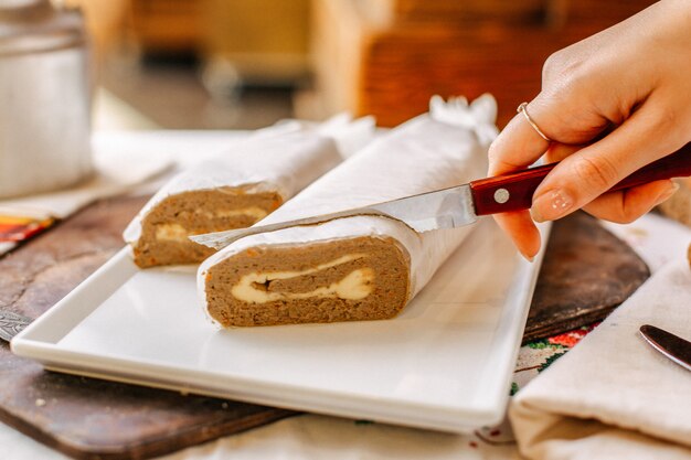 Una vista frontal paté vegetal sabroso salado en rodajas por mujer dentro de plato blanco rollos comida