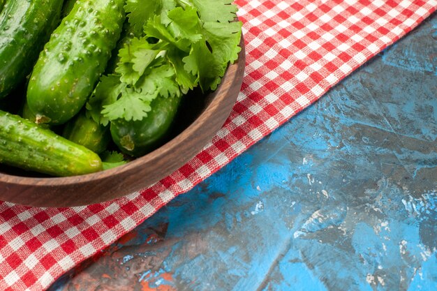 Vista frontal pepinos frescos dentro de la placa sobre fondo azul salud dieta comida ensalada de color maduro