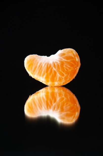 Vista frontal pequeña rodaja de mandarina sobre pared negra árbol de bebida jugo de fruta cítrica pomelo naranja oscuridad