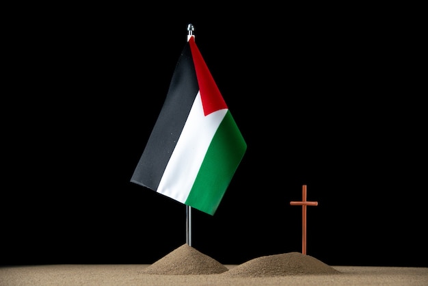 Vista frontal de la pequeña tumba con bandera palestina en negro
