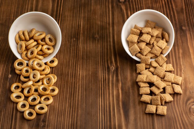 Vista frontal pequeñas galletas y galletas saladas en el escritorio de madera marrón