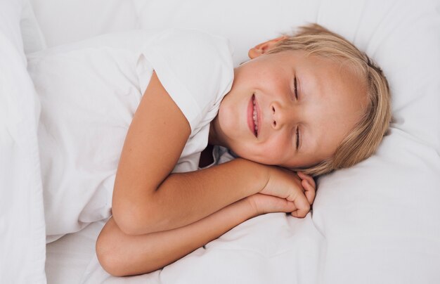 Vista frontal pequeño niño que tiene dulces sueños