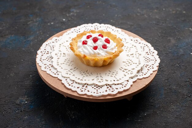 Vista frontal pequeño pastel cremoso con frutos rojos en el escritorio oscuro crema dulce de azúcar