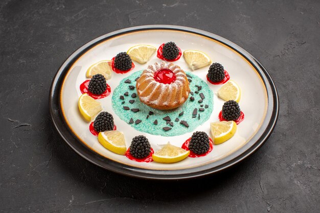 Vista frontal pequeño pastel delicioso con confituras y rodajas de limón dentro de la placa sobre fondo oscuro fruta cítrica galleta galleta dulce