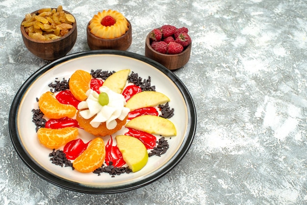 Vista frontal pequeño pastel con frutas en rodajas y pasas sobre fondo blanco dulce galleta azúcar frutas pastel de galleta