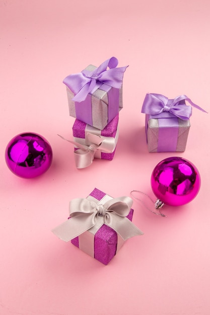 Foto gratuita vista frontal pequeños regalos con juguetes de árbol de navidad en la mesa rosa