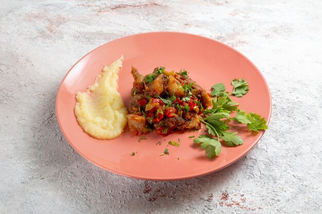 Vista frontal pequeños trozos de carne con puré de patatas y verduras sobre superficie blanca