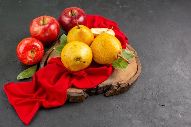 Vista frontal de las peras dulces frescas con manzanas en la mesa oscura de color suave fresco maduro