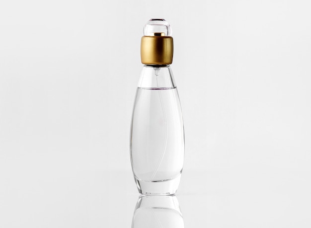 Una vista frontal de perfume dentro de la botella con tapa dorada en el blanco