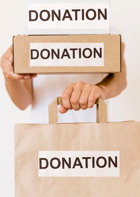 Vista frontal de la persona con bolsa y cajas de donación