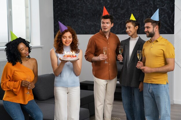 Vista frontal de personas celebrando con pastel