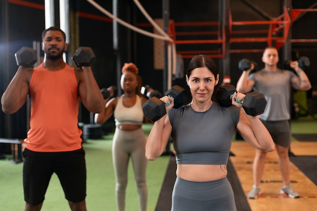 Foto gratuita vista frontal de personas entrenando juntas en el gimnasio