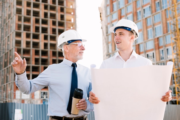 Vista frontal de personas con proyecto de construcción y café