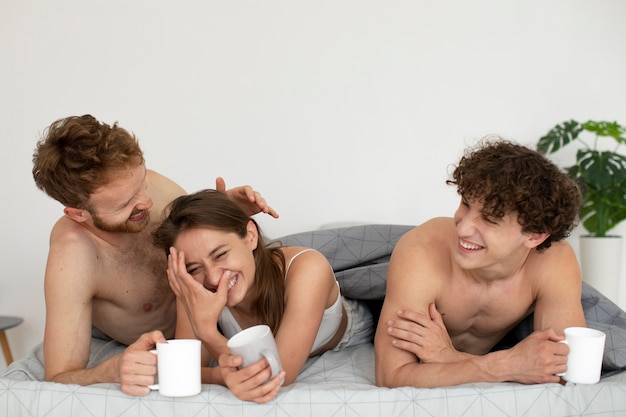 Foto gratuita vista frontal de personas sonrientes acostadas en la cama