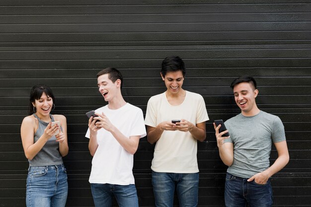 Vista frontal de personas con teléfonos móviles