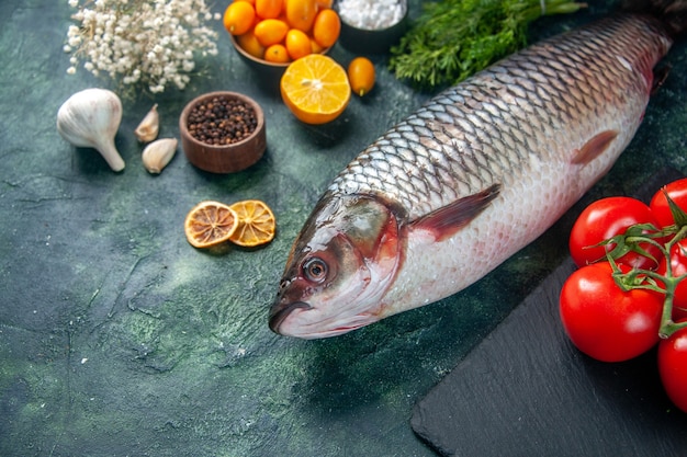 Foto gratuita vista frontal pescado crudo fresco con tomates y verduras en superficie oscura alimentos salud agua pescado color comida dieta ensalada pimienta mariscos océano