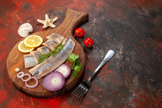 Vista frontal de pescado fresco en rodajas con aros de cebolla en bocadillo de carne de ensalada de color marisco oscuro