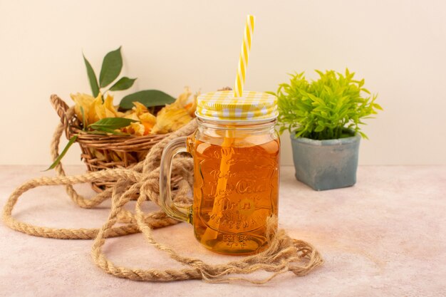 Una vista frontal physalises naranja pelado dentro de la canasta con jugo en el escritorio rosa