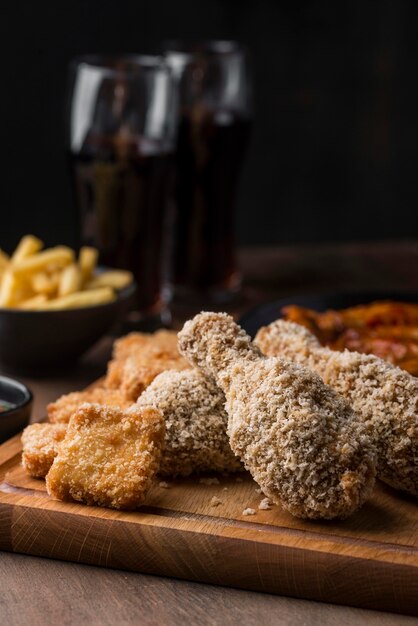 Vista frontal de las piernas de pollo frito con bebidas gaseosas