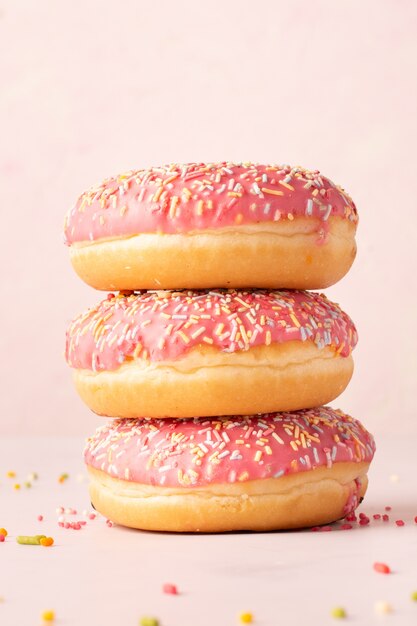 Vista frontal de la pila de donas con chispitas de colores y acristalamiento