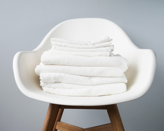 Vista frontal pila de toallas en una silla