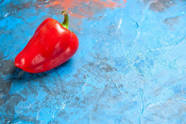 Vista frontal de pimiento rojo en la mesa azul foto en color comida ensalada de verduras