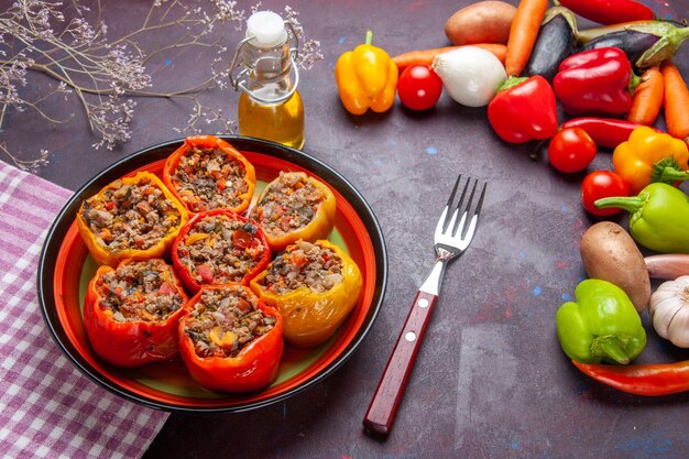 Vista frontal de pimientos cocidos con carne molida y verduras frescas en la superficie oscura comida comida vegetal carne dolma