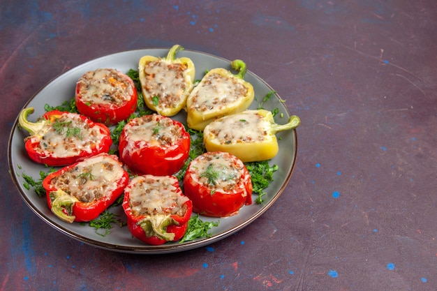 Foto gratuita vista frontal de pimientos horneados con queso verde y carne dentro de la placa sobre el fondo oscuro hornear cena plato comida comida