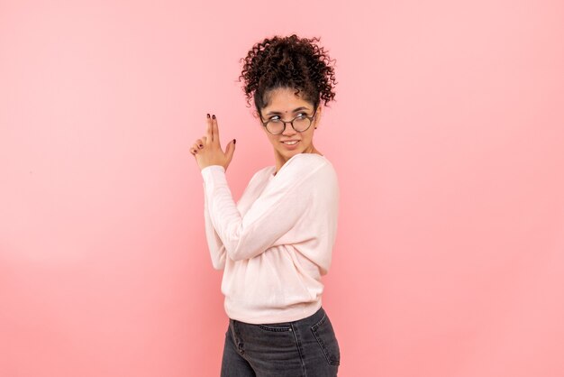 Vista frontal de la pistola de imitación bastante femenina sosteniendo en rosa