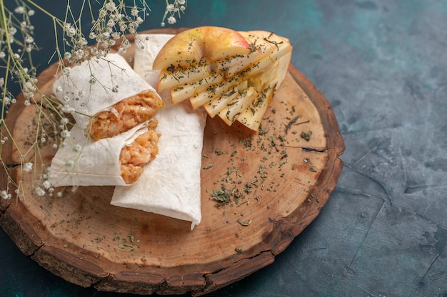 Vista frontal de pita de masa enrollada en rodajas con relleno de carne en el escritorio azul oscuro