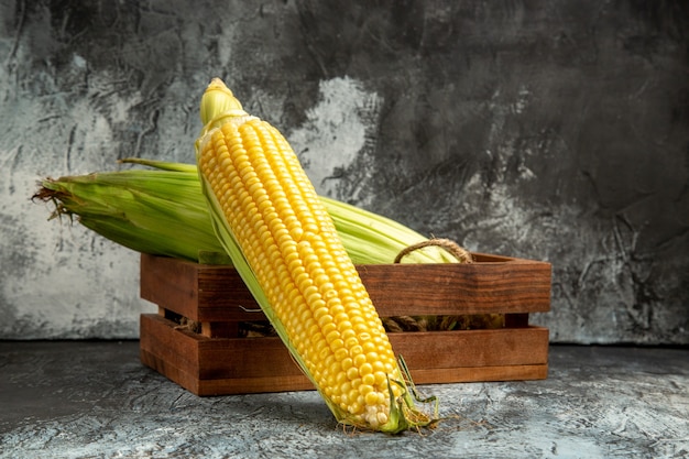 Foto gratuita vista frontal de la planta de maíz crudo fresco amarillo sobre fondo oscuro-claro