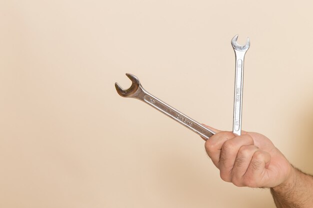 Vista frontal plata herramientas sostenidas por macho sobre fondo blanco herramienta instrumento macho