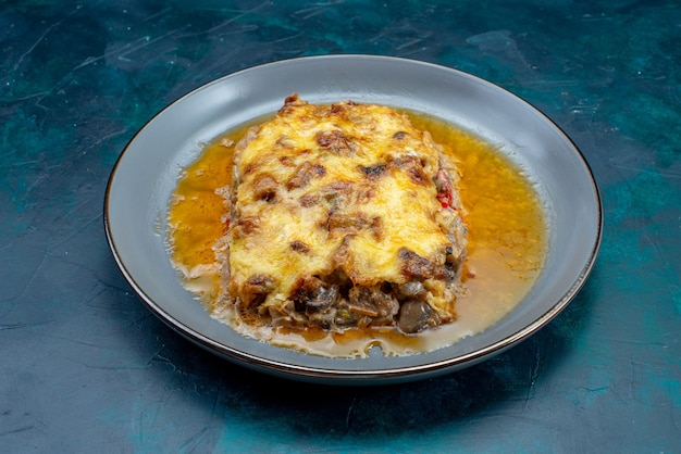 Vista frontal del plato de carne cocida con salsa y champiñones dentro de la placa en el escritorio azul oscuro plato de carne cena comida comida