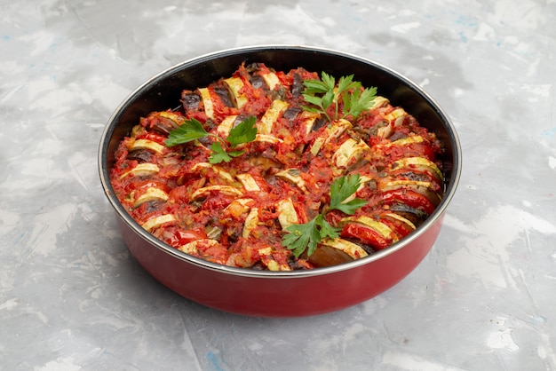 Vista frontal del plato de verduras cocidas dentro de la sartén sobre el escritorio brillante