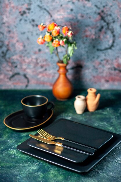 Vista frontal platos cuadrados oscuros con tenedor y cuchillo de oro en el escritorio oscuro cubiertos restaurante almuerzo plato de color bebida de té